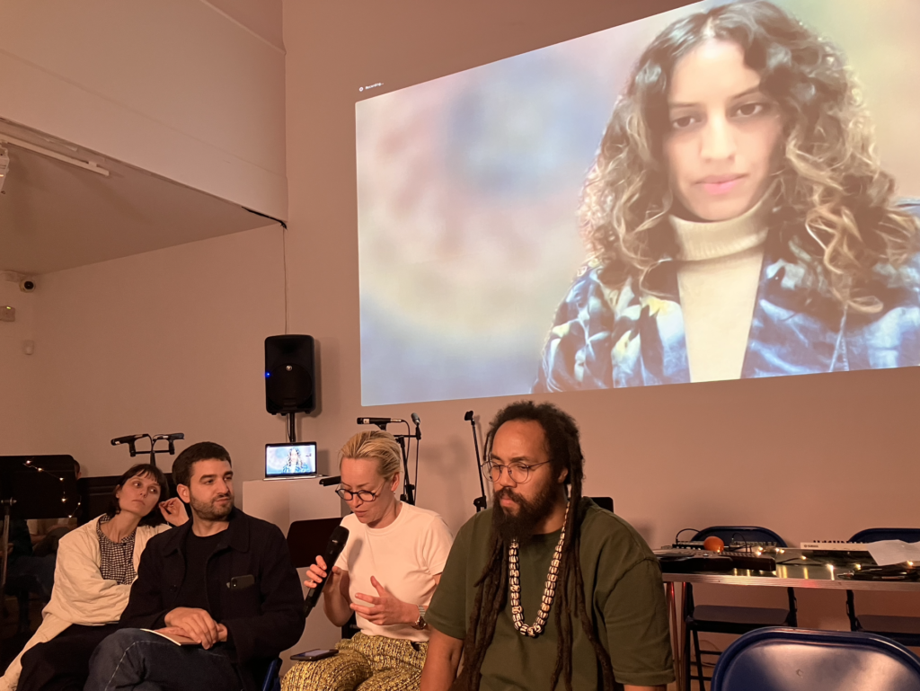 From left to right Lou-Atessa Marcellin, Charles Pryor, Susannah Haslam and Apex Zero take part in a panel discussion with Megha Ralapati projected on the screen.
